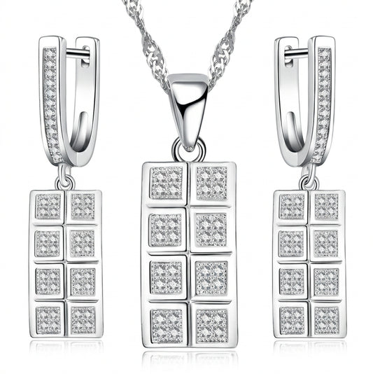 A silver-toned jewelry set featuring a rectangular pendant necklace, matching drop earrings, and a chain on a white background. The pendant and earrings are decorated with multiple small clear square stones.