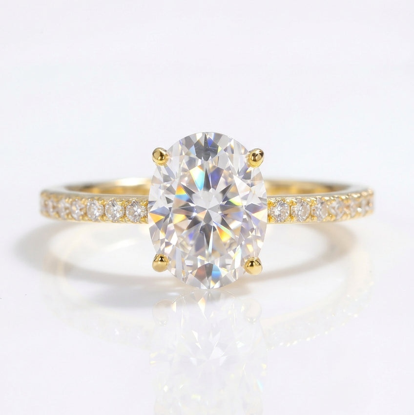 A yellow gold ring featuring a large oval-cut moissanite center stone and a pavé-set diamond band, displayed on a clean white background with 'GRA SILVER JEWELRY' and 'MOISSANITE' text overlays.