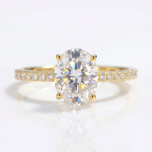 A yellow gold ring featuring a large oval-cut moissanite center stone and a pavé-set diamond band, displayed on a clean white background with 'GRA SILVER JEWELRY' and 'MOISSANITE' text overlays.