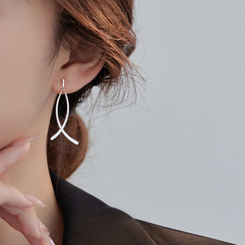 Close-up of an earring worn by a person with a neutral background
