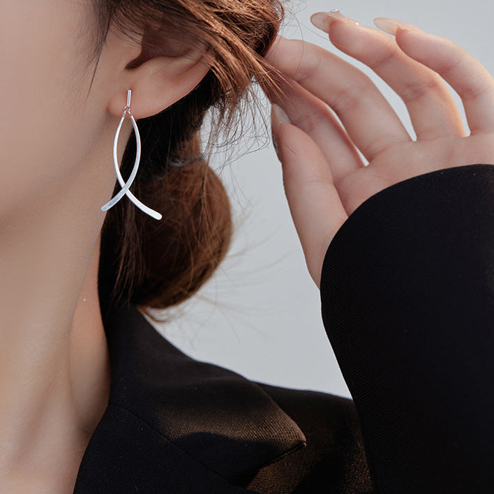 Person wearing a silver earring with text about new fashion design and sterling silver earrings.