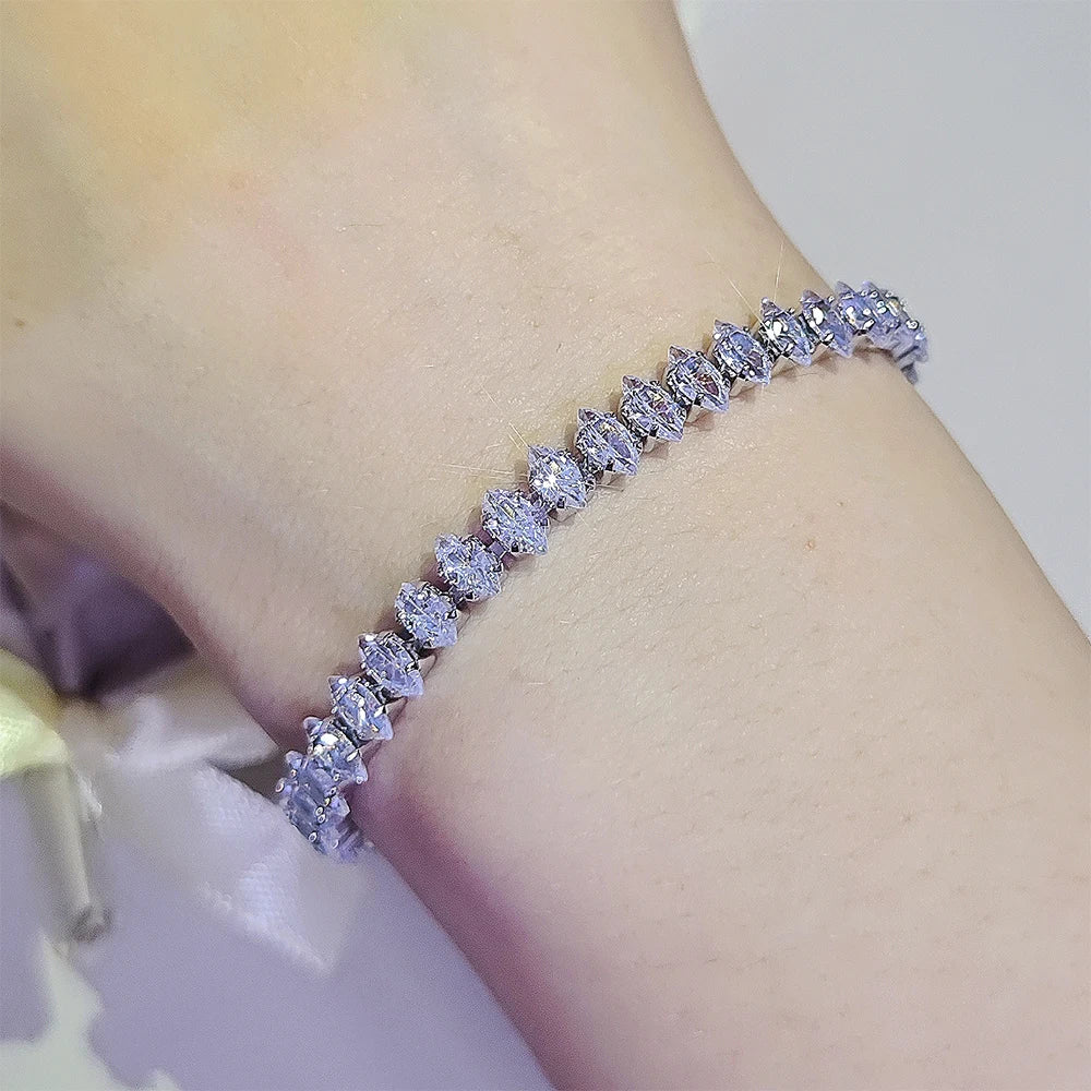 Silver bracelet with clear stones on a wrist against a blurred background